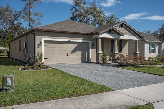 view of front facade with a garage, a front lawn, decorative driveway, and stucco siding