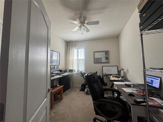 office area featuring light colored carpet, a textured ceiling, and a ceiling fan