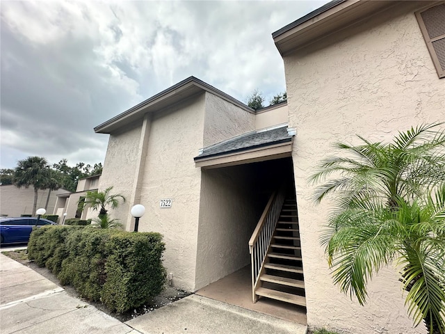 7522 Needle Leaf Pl Unit 27, Tampa, FL 33617 - view of side of home featuring stairway and stucco siding