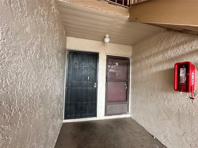 property entrance with stucco siding