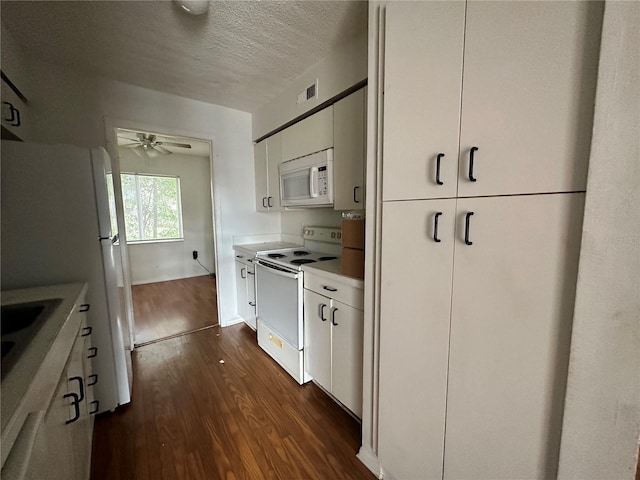 kitchen featuring dark wood finished floors, light countertops, visible vents, white cabinets, and white appliances