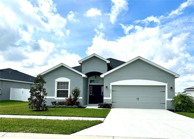 single story home with a garage, a front lawn, concrete driveway, and stucco siding