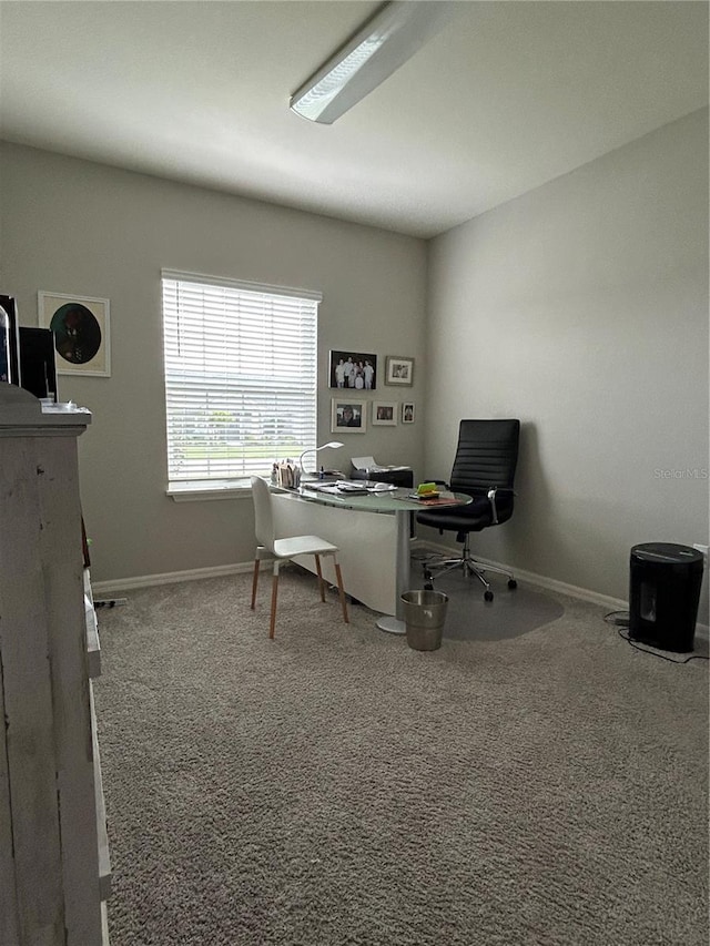 carpeted home office featuring baseboards