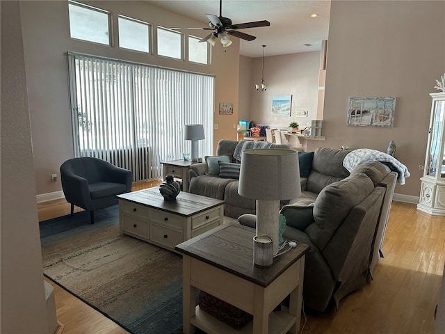 living room with light wood-type flooring, ceiling fan, and plenty of natural light