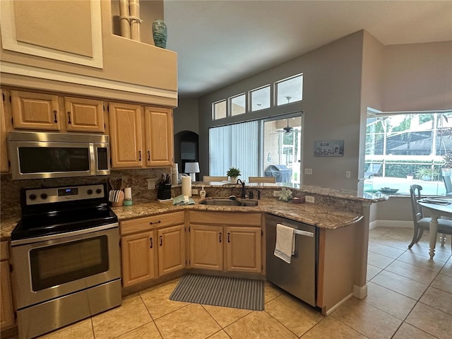 kitchen with light tile patterned flooring, appliances with stainless steel finishes, sink, and kitchen peninsula