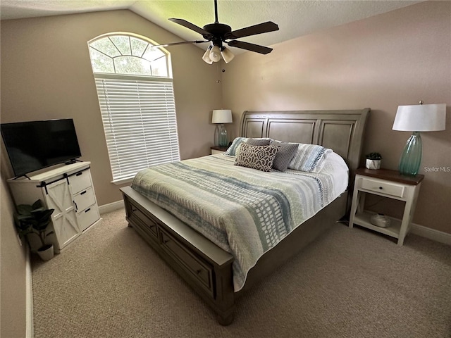 bedroom featuring a textured ceiling, lofted ceiling, light colored carpet, and ceiling fan