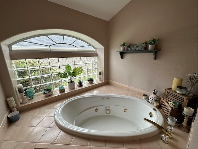 bathroom featuring tiled bath and vaulted ceiling