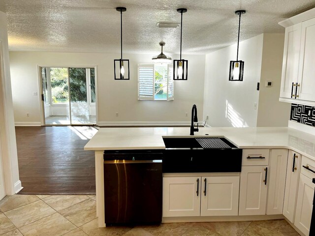 9319 SE 173rd Hyacinth St, The Villages, FL 32162 - kitchen featuring white cabinetry, light countertops, dishwasher, and decorative light fixtures