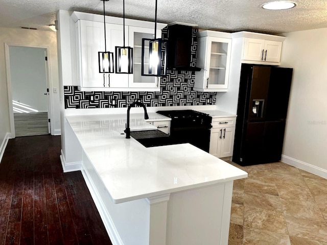 9319 SE 173rd Hyacinth St, The Villages, FL 32162 - kitchen featuring a textured ceiling, white cabinets, hanging light fixtures, black appliances, and glass insert cabinets