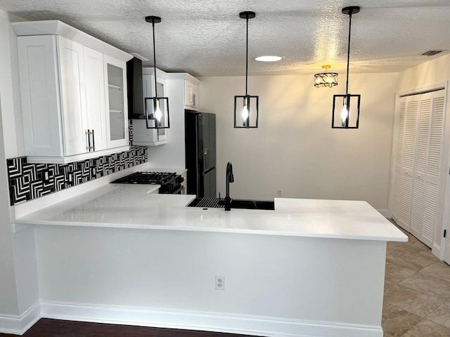 9319 SE 173rd Hyacinth St, The Villages, FL 32162 - kitchen with light countertops, hanging light fixtures, and a peninsula