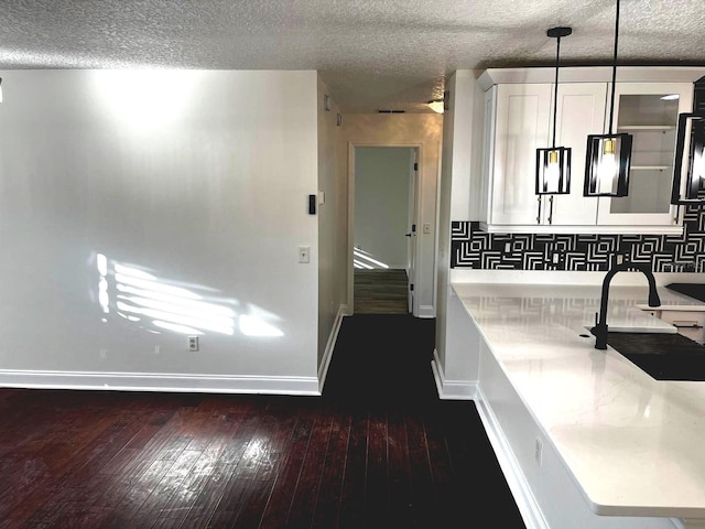 9319 SE 173rd Hyacinth St, The Villages, FL 32162 - bathroom featuring a textured ceiling, a sink, wood finished floors, baseboards, and tasteful backsplash
