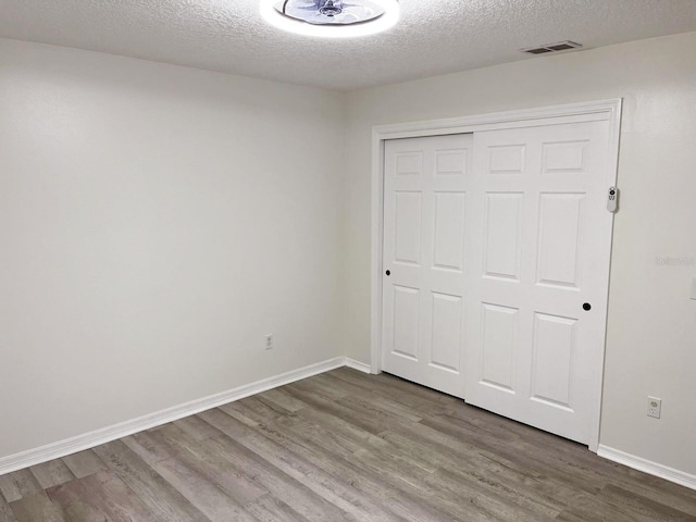 9319 SE 173rd Hyacinth St, The Villages, FL 32162 - unfurnished bedroom featuring baseboards, a closet, visible vents, and wood finished floors
