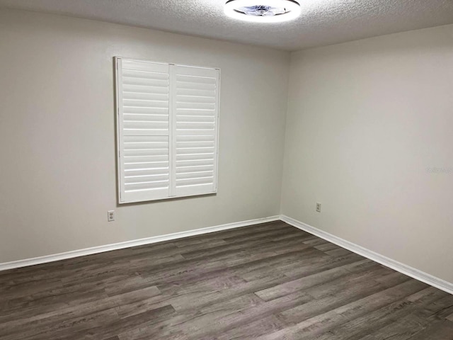 9319 SE 173rd Hyacinth St, The Villages, FL 32162 - spare room with baseboards, dark wood finished floors, and a textured ceiling
