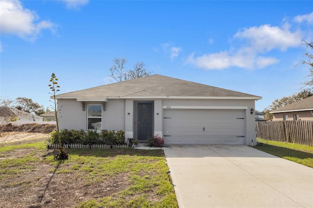 ranch-style house featuring concrete driveway, stucco siding, an attached garage, fence, and a front yard