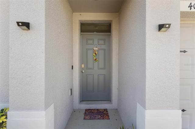 property entrance with stucco siding