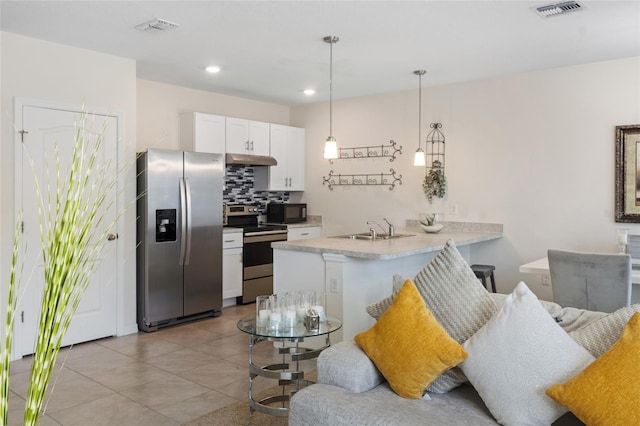 kitchen with stainless steel appliances, a peninsula, visible vents, white cabinetry, and decorative light fixtures