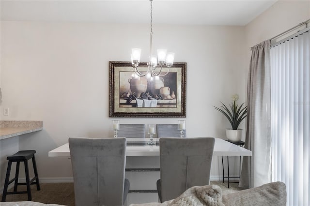 dining room featuring baseboards, a chandelier, and dark colored carpet