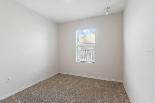 unfurnished room with carpet floors and baseboards