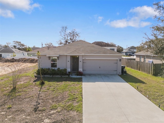 view of front of property featuring a garage, fence, concrete driveway, stucco siding, and a front yard