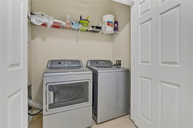 laundry room with laundry area, light tile patterned flooring, and washing machine and dryer