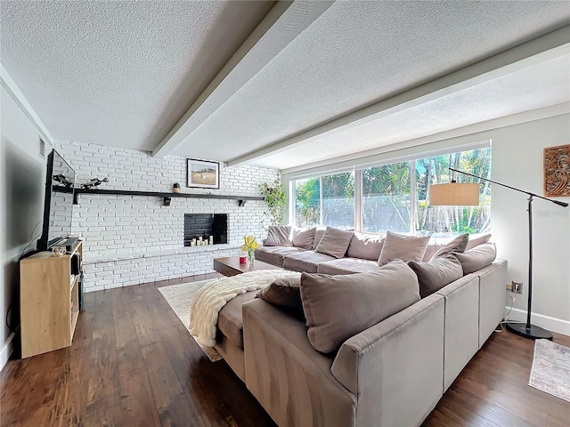 living room featuring beam ceiling, brick wall, a textured ceiling, a fireplace, and dark hardwood / wood-style floors