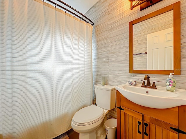 bathroom with tile walls, toilet, vanity, and a shower with curtain