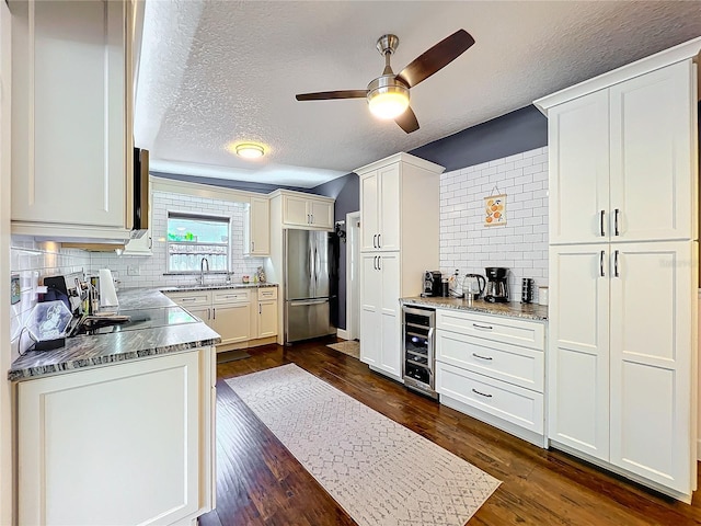 3004 Lake Margaret Dr, Orlando, FL 32806 - kitchen with freestanding refrigerator, beverage cooler, a textured ceiling, backsplash, and dark wood-type flooring