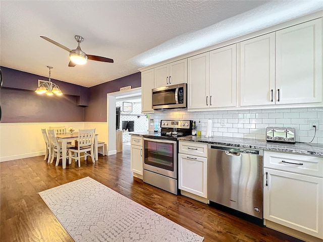 3004 Lake Margaret Dr, Orlando, FL 32806 - kitchen featuring stainless steel appliances, a chandelier, decorative backsplash, a ceiling fan, and a textured ceiling