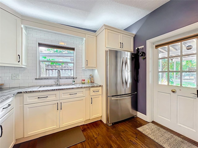 3004 Lake Margaret Dr, Orlando, FL 32806 - kitchen featuring freestanding refrigerator, dark wood-style floors, decorative backsplash, light stone counters, and vaulted ceiling
