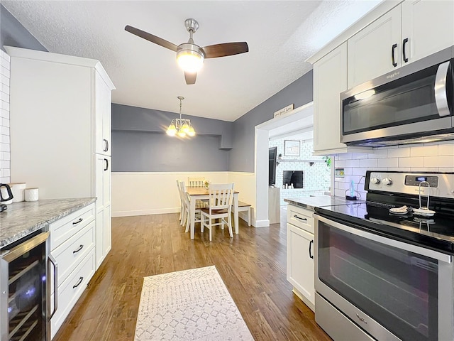 3004 Lake Margaret Dr, Orlando, FL 32806 - kitchen with appliances with stainless steel finishes, beverage cooler, wood finished floors, a ceiling fan, and a textured ceiling