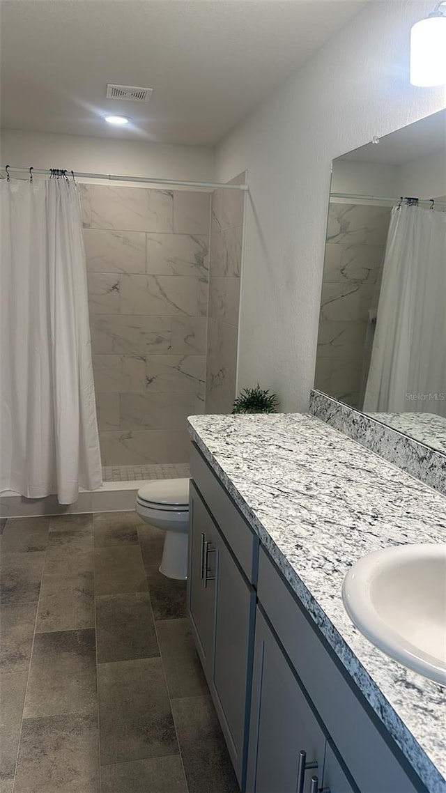 bathroom featuring toilet, curtained shower, and vanity