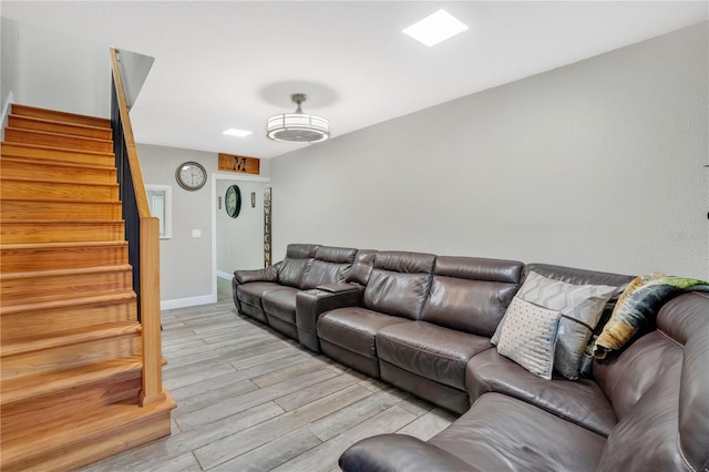 living area featuring light wood finished floors, stairs, and baseboards