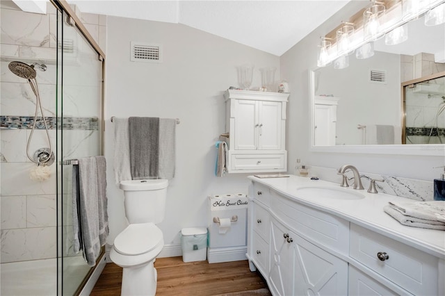 bathroom featuring vaulted ceiling, wood finished floors, a shower stall, and visible vents