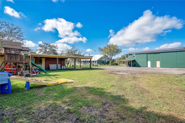 view of yard with a pole building and a playground