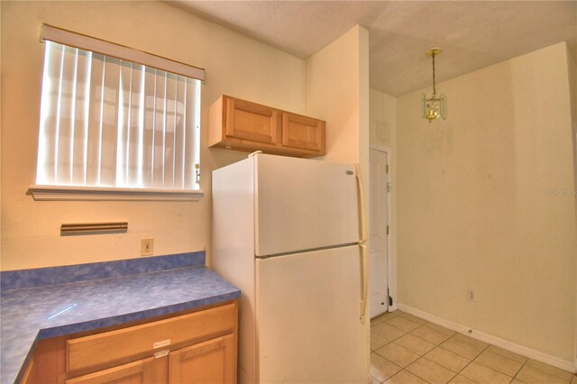500 Monroe Cir, Davenport, FL 33896 - kitchen with pendant lighting, dark countertops, light tile patterned floors, baseboards, and freestanding refrigerator
