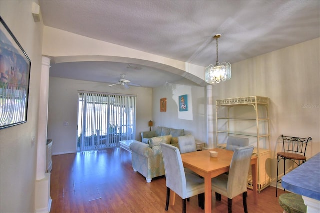 500 Monroe Cir, Davenport, FL 33896 - dining space with arched walkways, baseboards, wood finished floors, and ceiling fan with notable chandelier