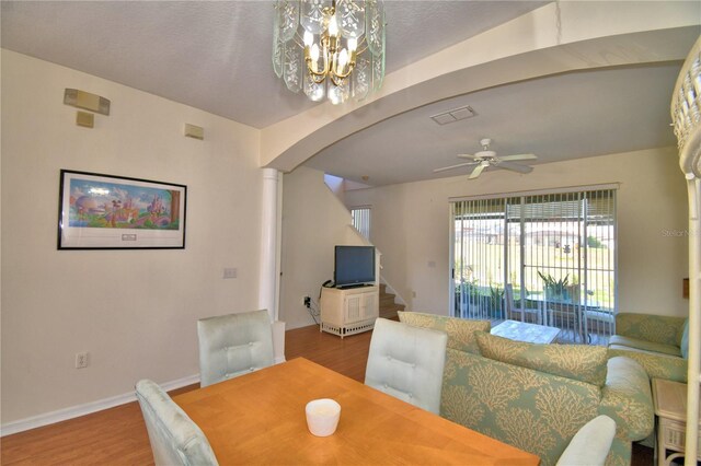 500 Monroe Cir, Davenport, FL 33896 - dining area featuring visible vents, wood finished floors, baseboards, arched walkways, and ceiling fan with notable chandelier