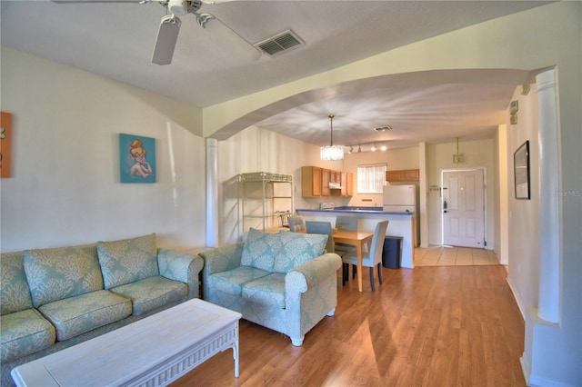 500 Monroe Cir, Davenport, FL 33896 - living room with visible vents, arched walkways, light wood-style flooring, and ceiling fan