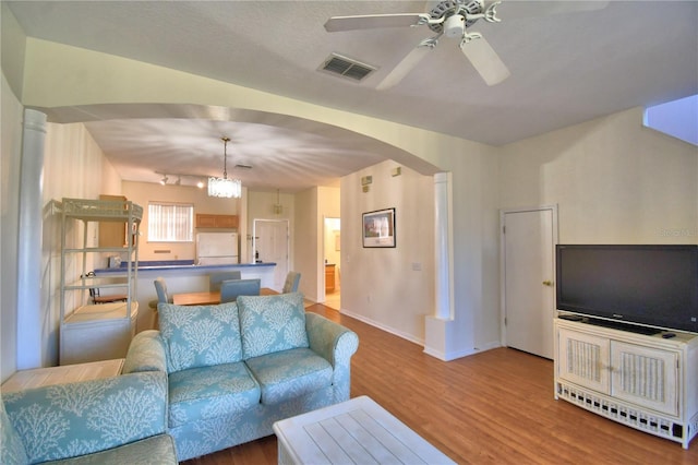 500 Monroe Cir, Davenport, FL 33896 - living area with arched walkways, a ceiling fan, baseboards, wood finished floors, and visible vents