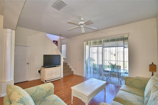 500 Monroe Cir, Davenport, FL 33896 - living room with a ceiling fan, baseboards, wood finished floors, visible vents, and stairway
