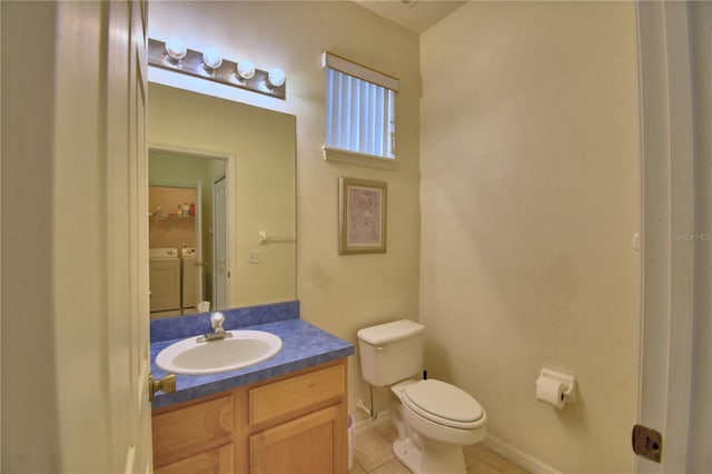500 Monroe Cir, Davenport, FL 33896 - bathroom with washing machine and dryer, vanity, tile patterned floors, baseboards, and toilet