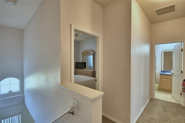 500 Monroe Cir, Davenport, FL 33896 - hallway with baseboards, an upstairs landing, light colored carpet, and visible vents