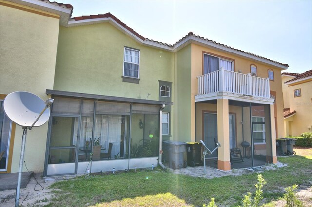 500 Monroe Cir, Davenport, FL 33896 - back of house with a tile roof, stucco siding, a sunroom, a balcony, and a yard