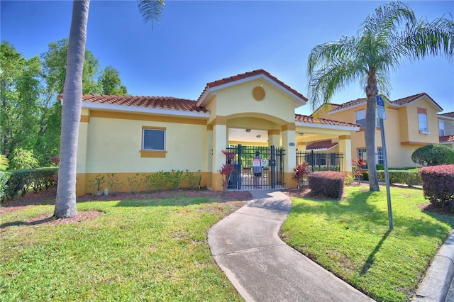 500 Monroe Cir, Davenport, FL 33896 - mediterranean / spanish house featuring a tiled roof, a front yard, a gate, fence private yard, and stucco siding