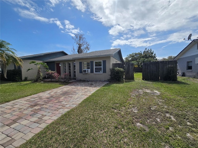 view of front facade featuring cooling unit, fence, a front lawn, and stucco siding