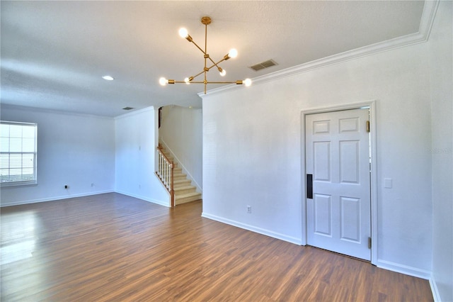 spare room featuring dark wood-style floors, visible vents, stairway, and crown molding