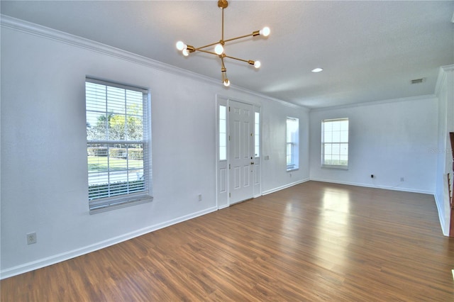 foyer entrance with dark wood-type flooring, a healthy amount of sunlight, and crown molding