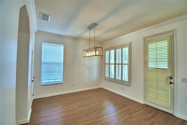 unfurnished dining area with ornamental molding, dark wood-type flooring, visible vents, and a healthy amount of sunlight