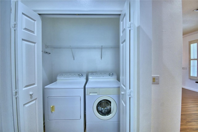 laundry area featuring laundry area, separate washer and dryer, wood finished floors, and baseboards