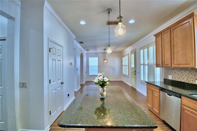 kitchen with dark stone counters, wood finished floors, a center island, dishwasher, and pendant lighting